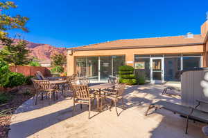 View of patio with a sunroom, outdoor dining area, and a mountain view