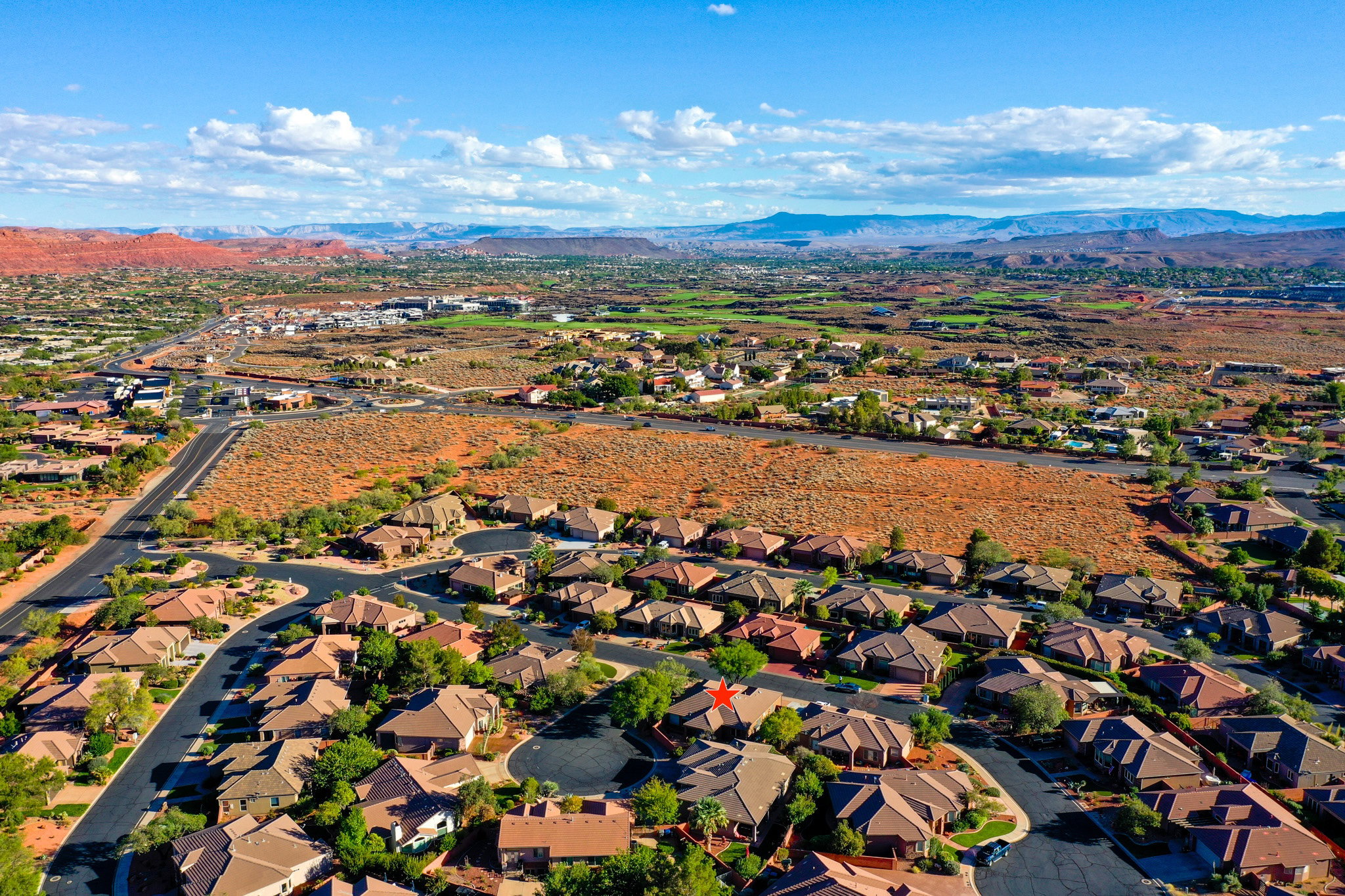 Aerial view of property and surrounding area featuring a mountain backdrop