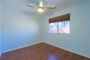 Unfurnished room featuring dark wood finished floors and a ceiling fan