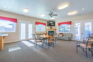 Dining space featuring french doors, a fireplace, light colored carpet, and recessed lighting