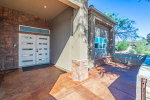 Doorway to property with stone siding and stucco siding