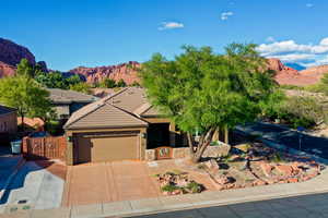 View of front of house with a mountain view, a garage, driveway, and a tile roof