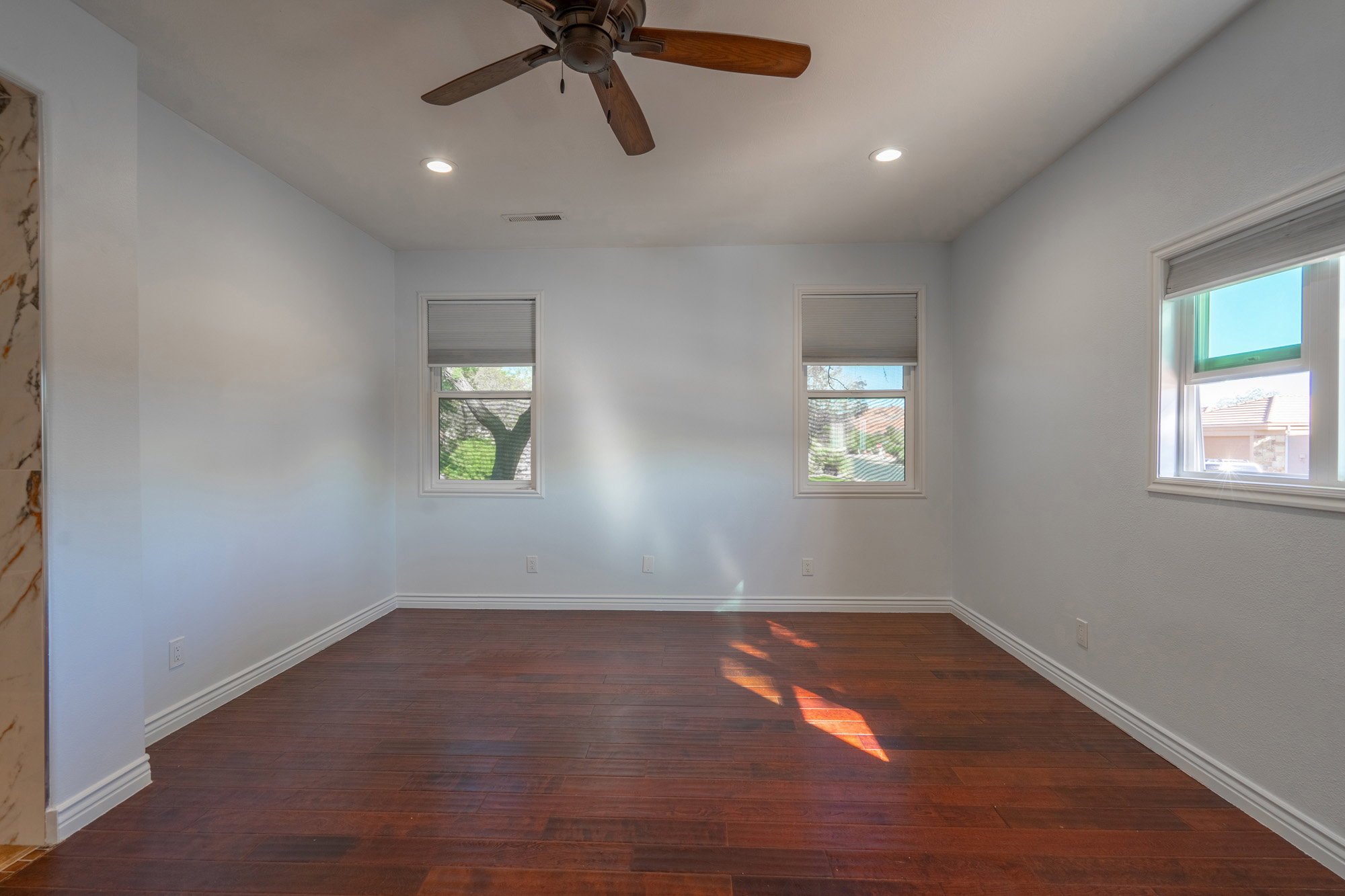 Spare room featuring dark wood-style flooring, plenty of natural light, ceiling fan, and recessed lighting