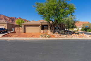 View of front of property featuring a mountain view, a garage, concrete driveway, stone siding, and a tile roof
