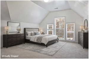 Bedroom featuring light carpet and lofted ceiling