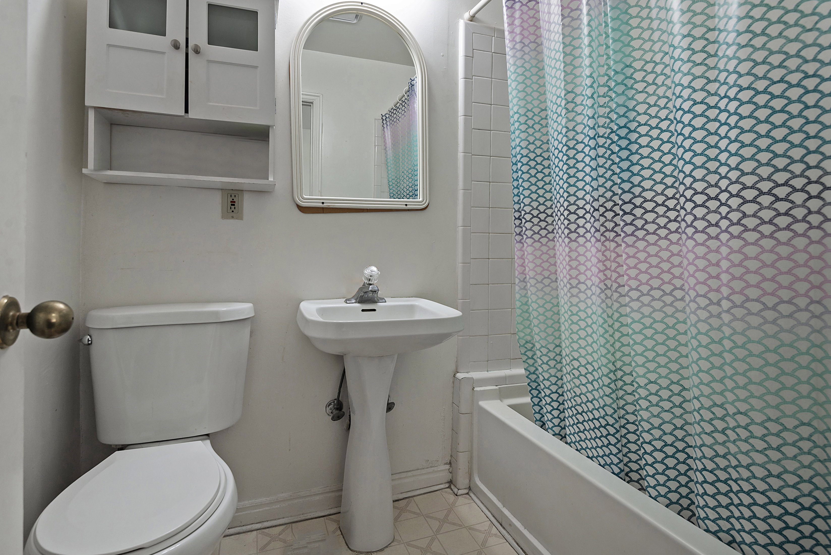 Bathroom featuring shower / bath combo and light floors