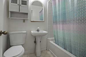 Bathroom featuring shower / bath combo and light floors