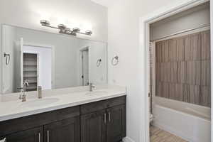 Bathroom featuring double vanity and shower / bath combo with shower curtain