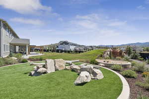 View of grassy yard with a patio area and a residential view