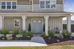 View of exterior entry featuring board and batten siding and covered porch