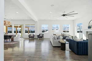 Living room with a chandelier, a fireplace, beamed ceiling, dark wood-style floors, and recessed lighting