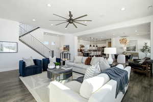 Living area featuring stairs, dark wood finished floors, and recessed lighting