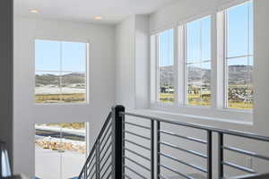 Stairway with a mountain view, healthy amount of natural light, and recessed lighting