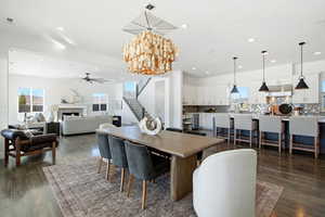 Dining space featuring a chandelier, healthy amount of natural light, a fireplace, stairway, and recessed lighting