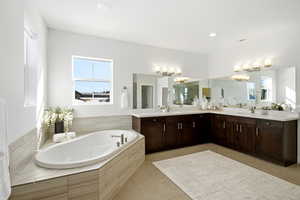 Full bath with a garden tub, double vanity, light tile patterned floors, a chandelier, and recessed lighting