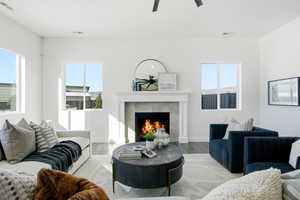 Living room featuring a tile fireplace, wood finished floors, and a ceiling fan