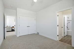 Unfurnished bedroom with light colored carpet, a closet, and ceiling fan