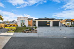 View of front of home featuring stucco siding, a garage, concrete driveway, and a front yard
