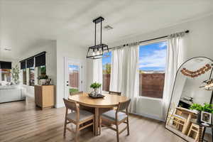 Dining room with light wood-style flooring and a chandelier