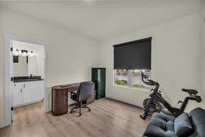 Office area featuring light wood-style floors and a sink