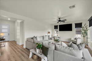 Living room with light wood finished floors and a ceiling fan