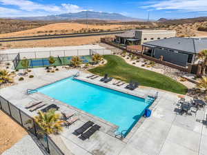 Community pool featuring a patio area, a fenced backyard, and a mountain view
