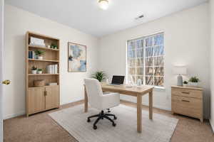 Home office featuring baseboards and light colored carpet