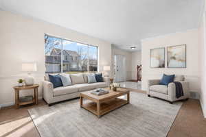 Carpeted living room with baseboards and crown molding