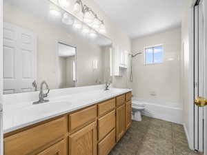 Full bathroom featuring double vanity and shower / tub combination