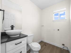 Half bathroom with vanity and dark wood-style floors