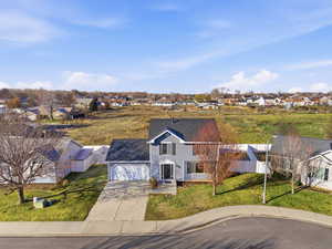 View of front of house with a residential view, driveway, a front lawn, and a garage