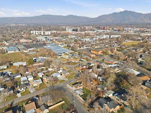 Aerial view of property and surrounding area featuring a mountain backdrop and nearby suburban area