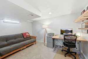 Home office with light carpet and baseboards