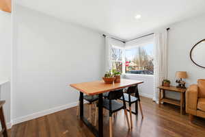 Dining area with dark wood finished floors and recessed lighting
