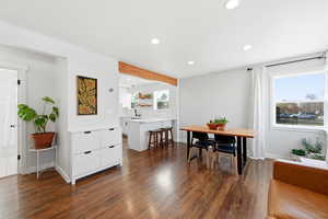 Dining area with dark wood finished floors, recessed lighting, and beamed ceiling