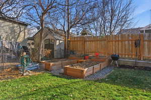 View of yard featuring a garden and a storage shed