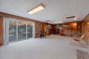 Recreation room with carpet flooring and brick wall