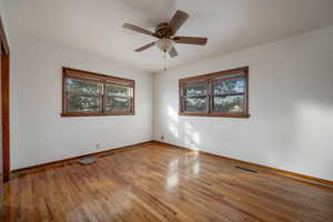 Master bedroom with light wood finished floors and ceiling fan