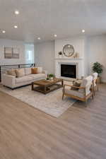 Living area with a high end fireplace, recessed lighting, and light wood-style flooring