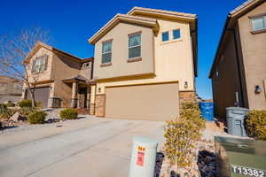 View of front of home featuring stone siding, concrete driveway, an attached garage, board and batten siding, and a tiled roof