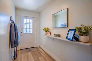 Doorway to outside featuring baseboards and wood finished floors