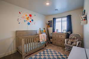 Bedroom featuring carpet and a nursery area