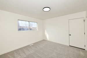 Spare room with carpet flooring and a textured ceiling