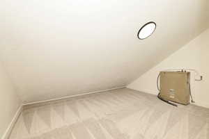 Bonus room featuring carpet floors and vaulted ceiling