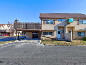 View of front facade with brick siding and an attached carport