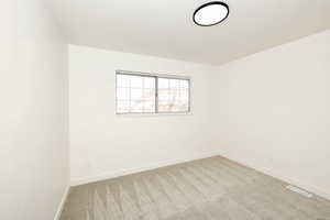 Carpeted spare room with baseboards