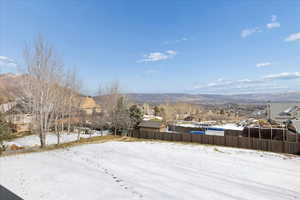 Yard covered in snow with a mountain view