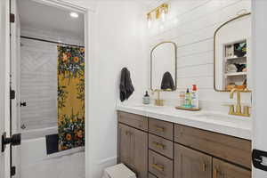 Full bathroom featuring shower / tub combo with curtain, double vanity, light tile patterned floors, and recessed lighting
