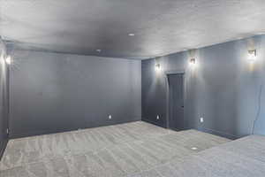 Empty room with carpet and a textured ceiling