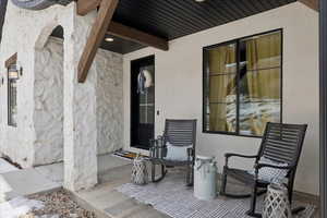 Doorway to property with stone siding and stucco siding
